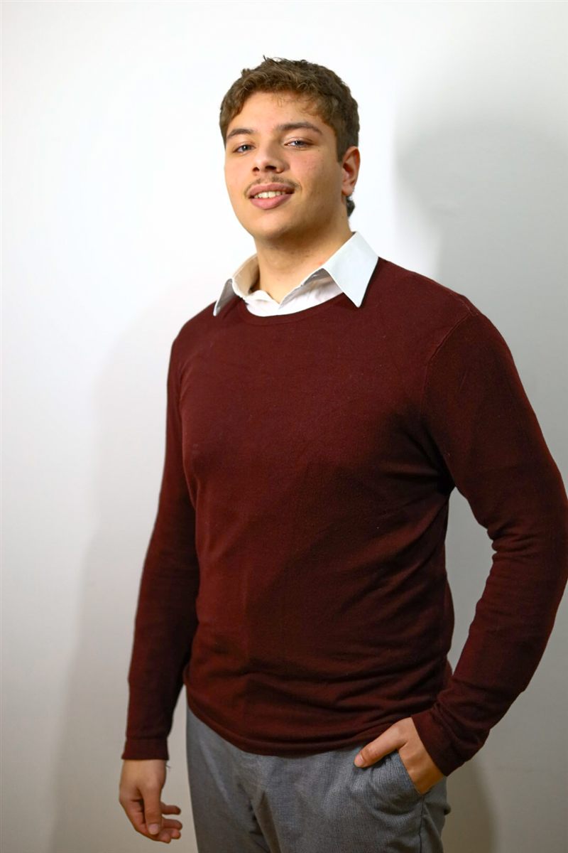 Retrato masculino de corpo inteiro em estúdio, suéter bordô sobre fundo claro